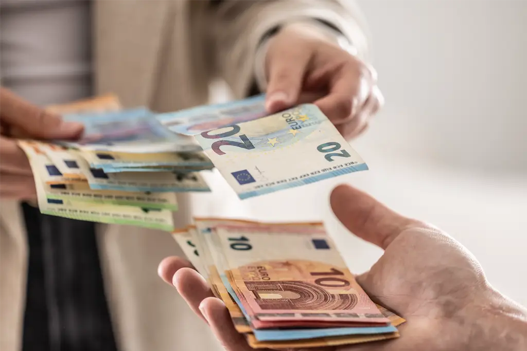 a photo of cash being received from one hand to another